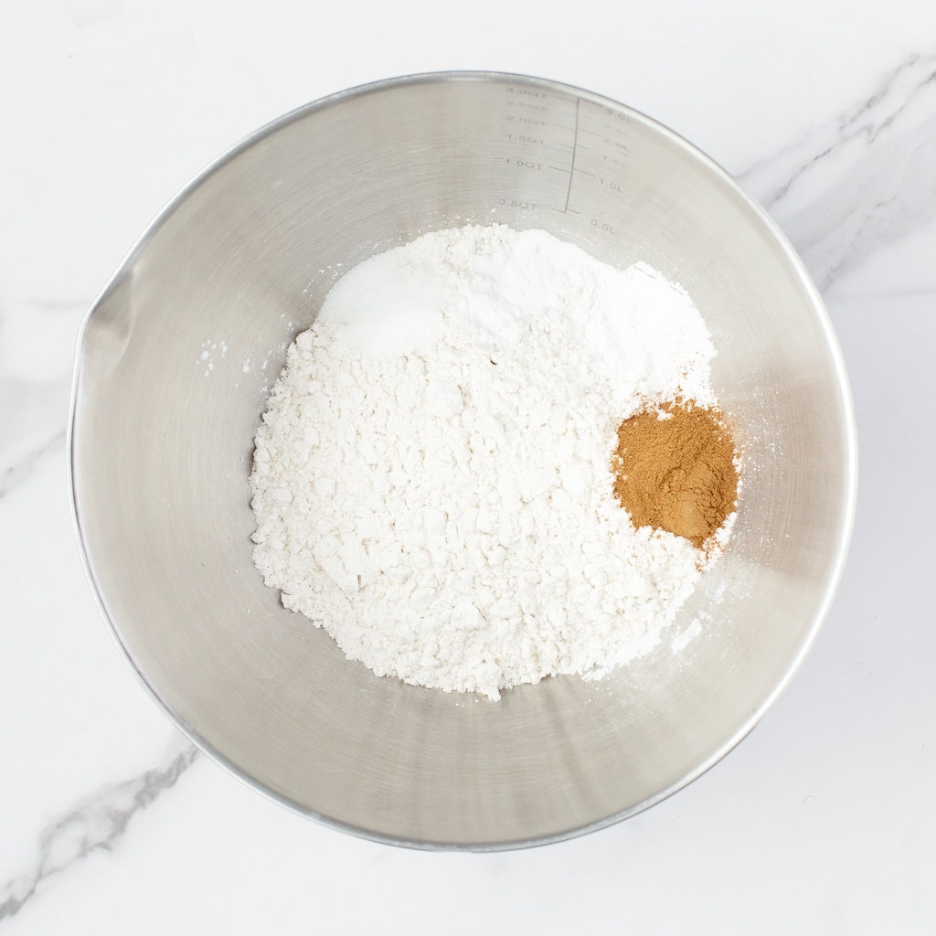 Metal mixing bowl with flour and dry ingredients.