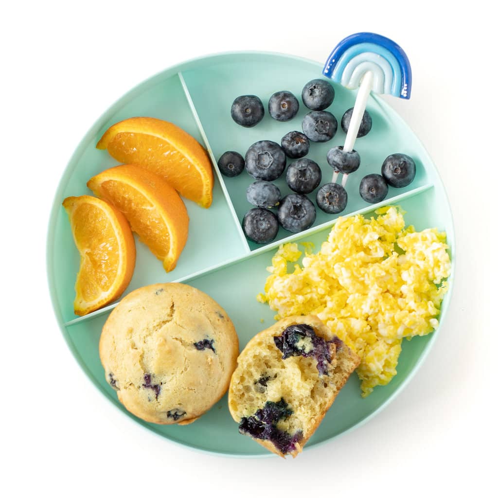Kids to play it against a white background that has three sections one with oranges, one with blueberries, one with blueberry muffins and scrambled eggs.