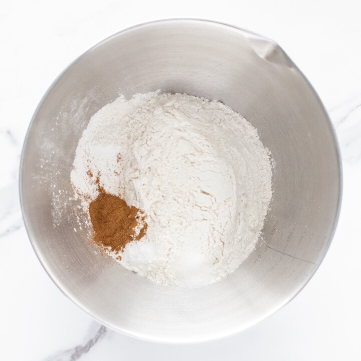 A silver mixing bowl full of dry ingredients for muffins.