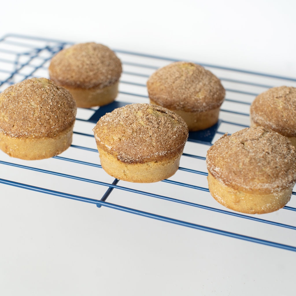 cinnamon muffins baked on a cooling rack with a white background. 
