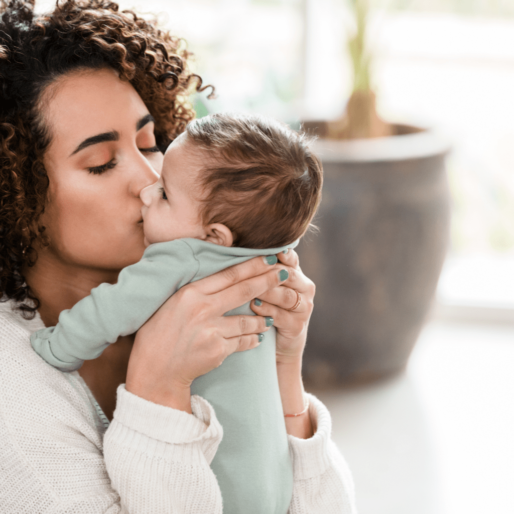 new mom kissing baby on the check