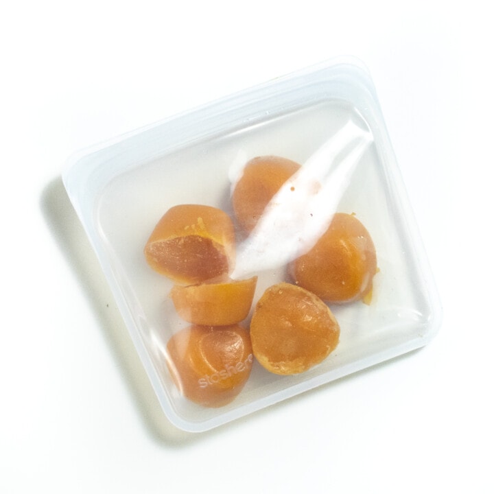 A stasher bag full of frozen apricot baby food purées.