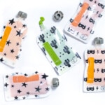 Scattered baby food pouches with different ingredients on the inside with a white background.
