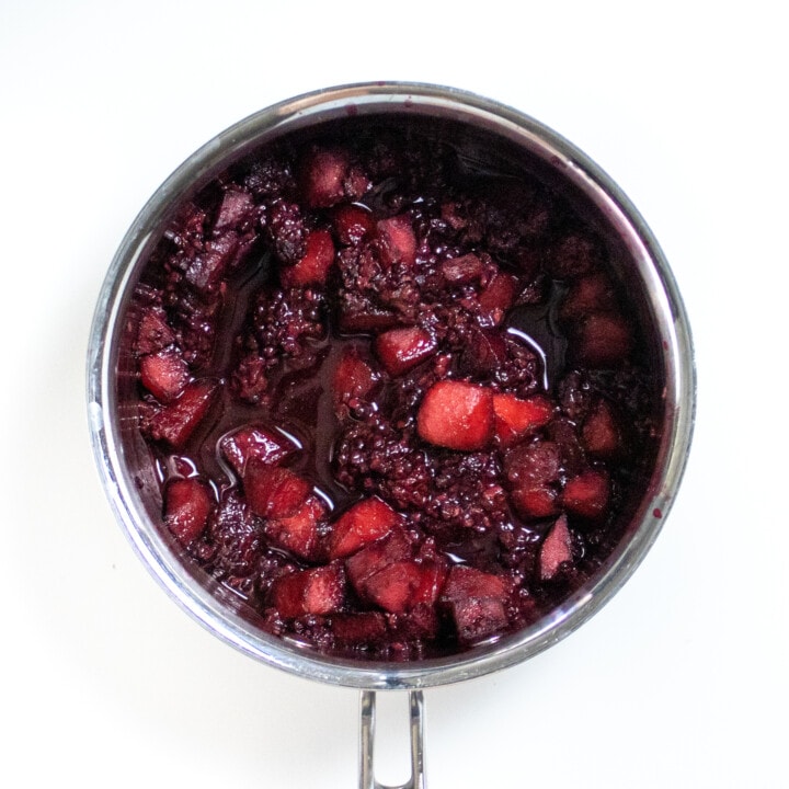 Small silver saucepan with simmered blackberries and apples ready to be blended.