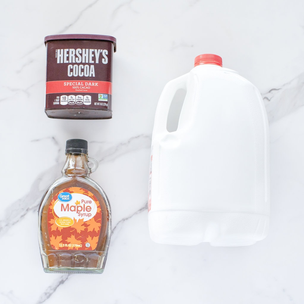 Ingredients for chocolate milk spread on a marble countertop.