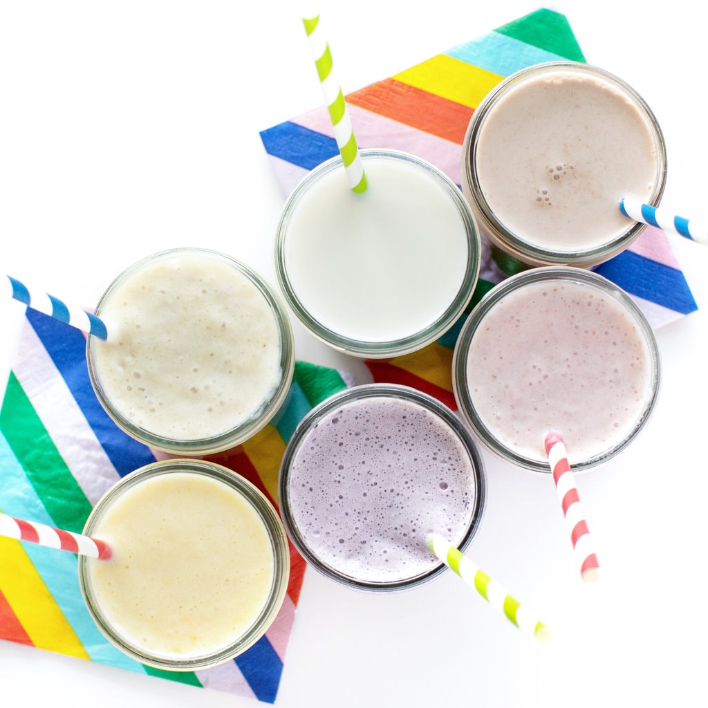 An overhead shot of different flavored milks and colorful napkins.