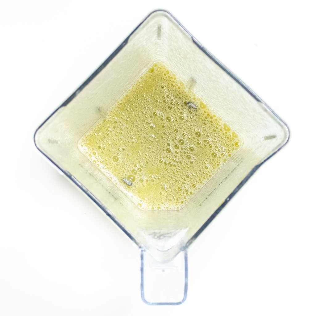 A clear blender with puréed grapes for popsicles.
