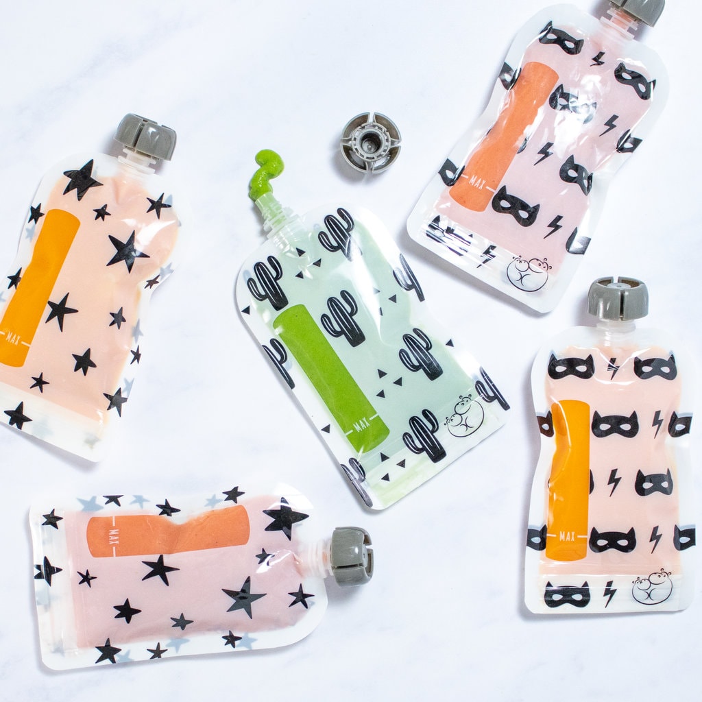 Scattered baby food pouches with different ingredients on the inside with a white background.