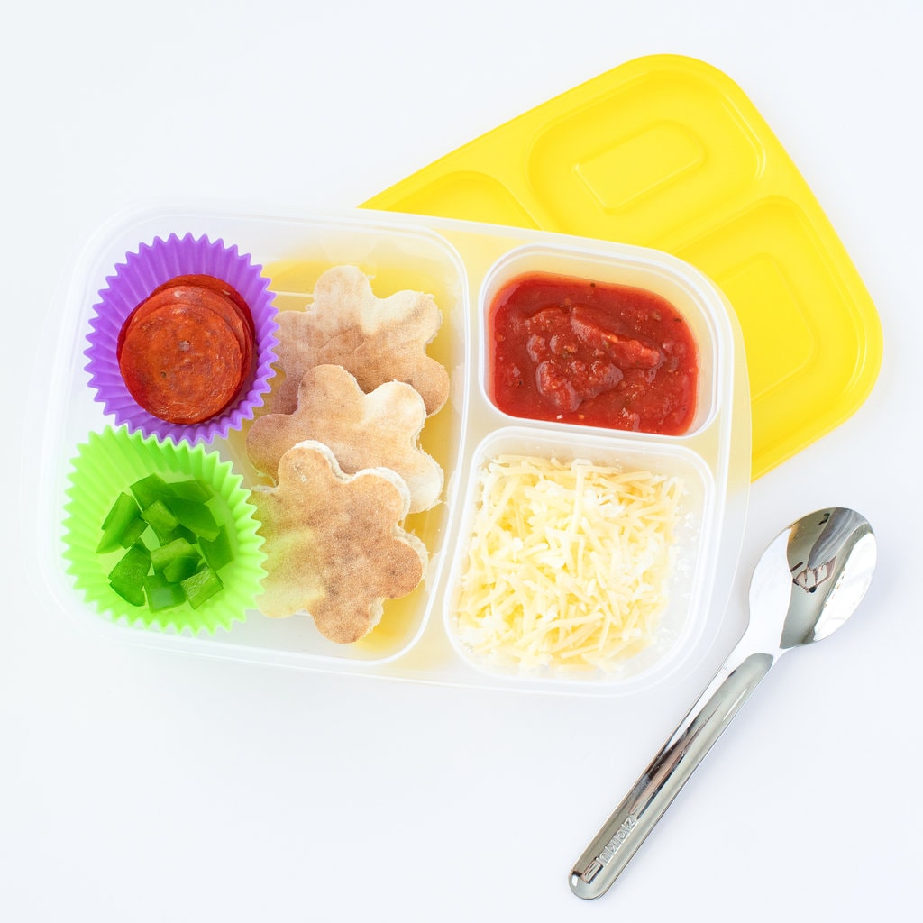 A lunchable for kids that includes pizza crust, shredded cheese, pizza sauce, pepperoni, and green peppers.