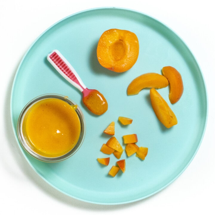 A blue kids plate with several different ways to feed apricots to baby.