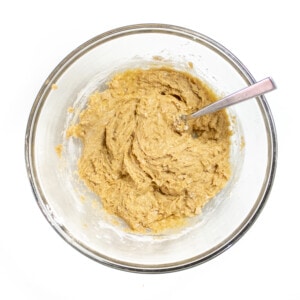 Clear bowl full of muffin batter against a white background.
