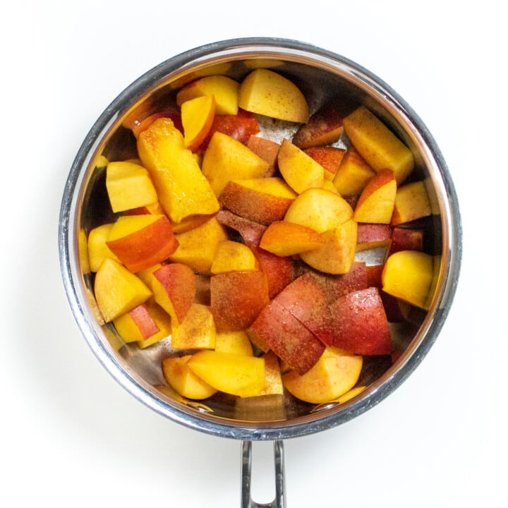 Small silver soft pan full of chopped nectarines and a pinch o