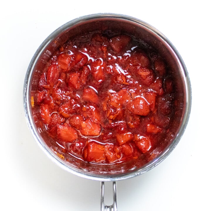 A silver sauce pan with simmered strawberries and carrots for Popsicles.
