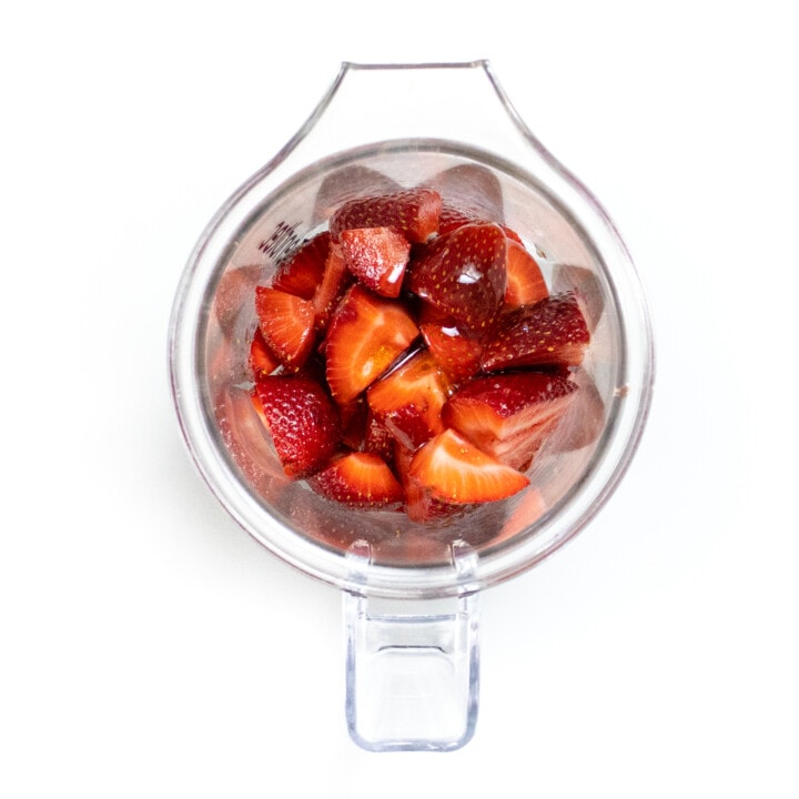 Clear blender with strawberries and honey. I got the way background.