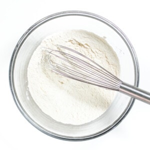 Clear mixing bowl with Ryan gradients for muffins against a white countertop.