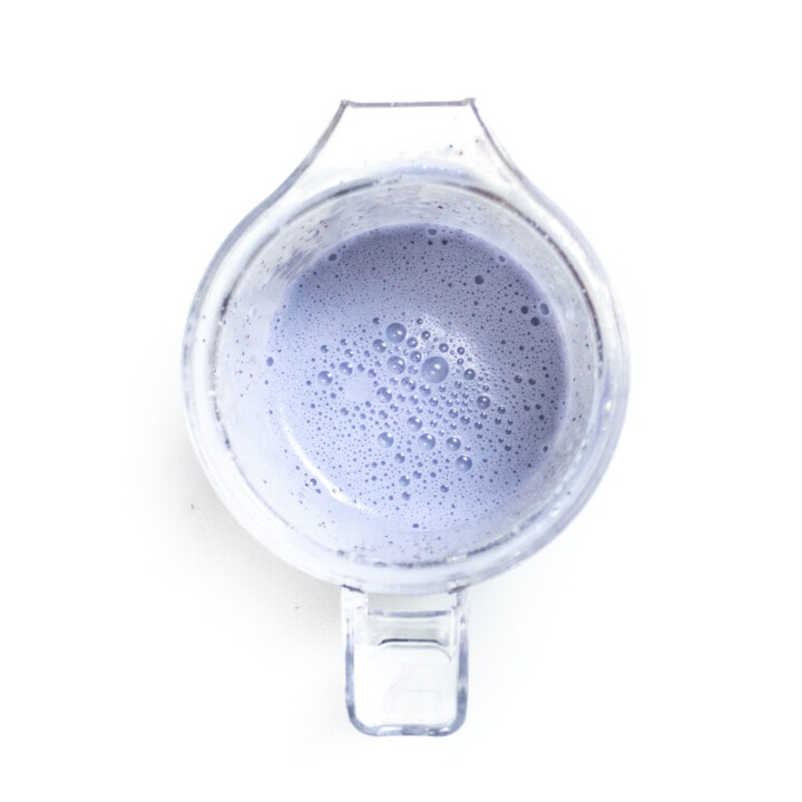 Clear blender full of blueberry breast milk popsicles.