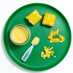 A green kids plate with corn for baby on it shown how to serve it different ways.