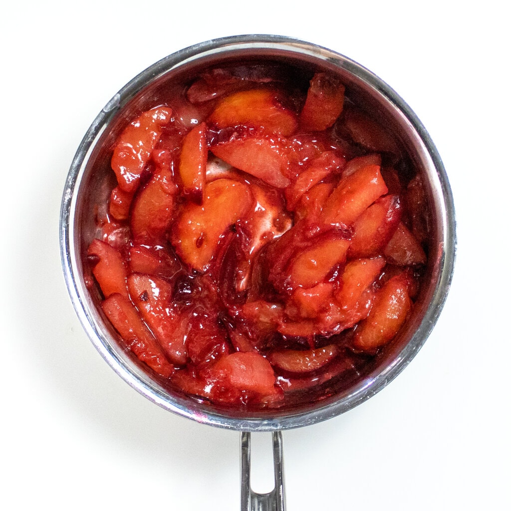 Simmer plums in a silver saucepan.