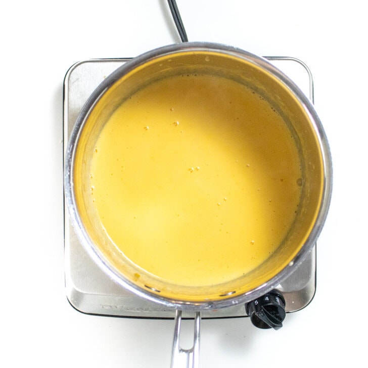 Silver sauce pan full of a homemade cheese sauce.