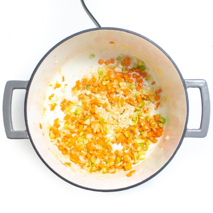 Large gray stock pot with cooked carrots, celery and onion.