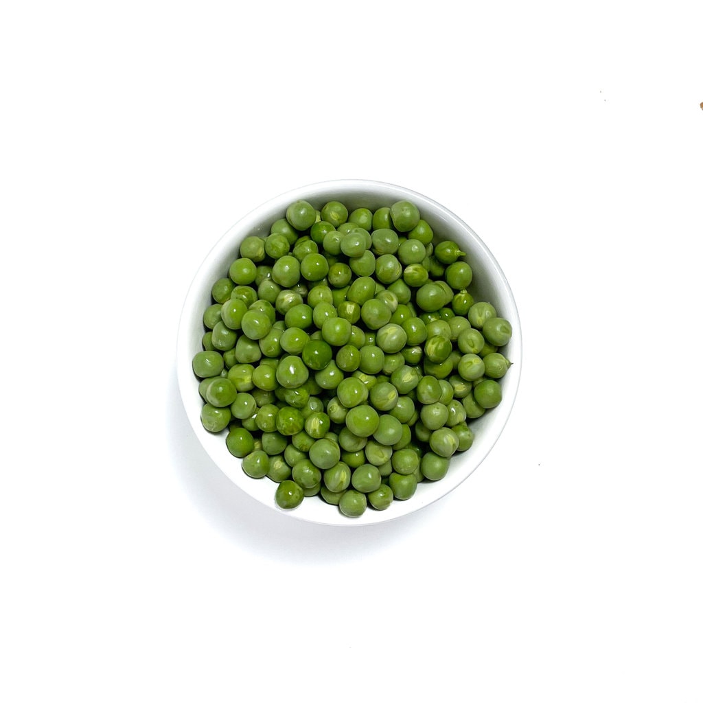 peas in a white bowl on the weed countertop.