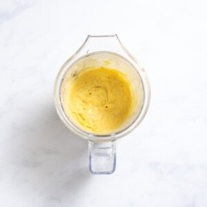 A clear jar sitting on my kitchen counter with parsnip puree inside.