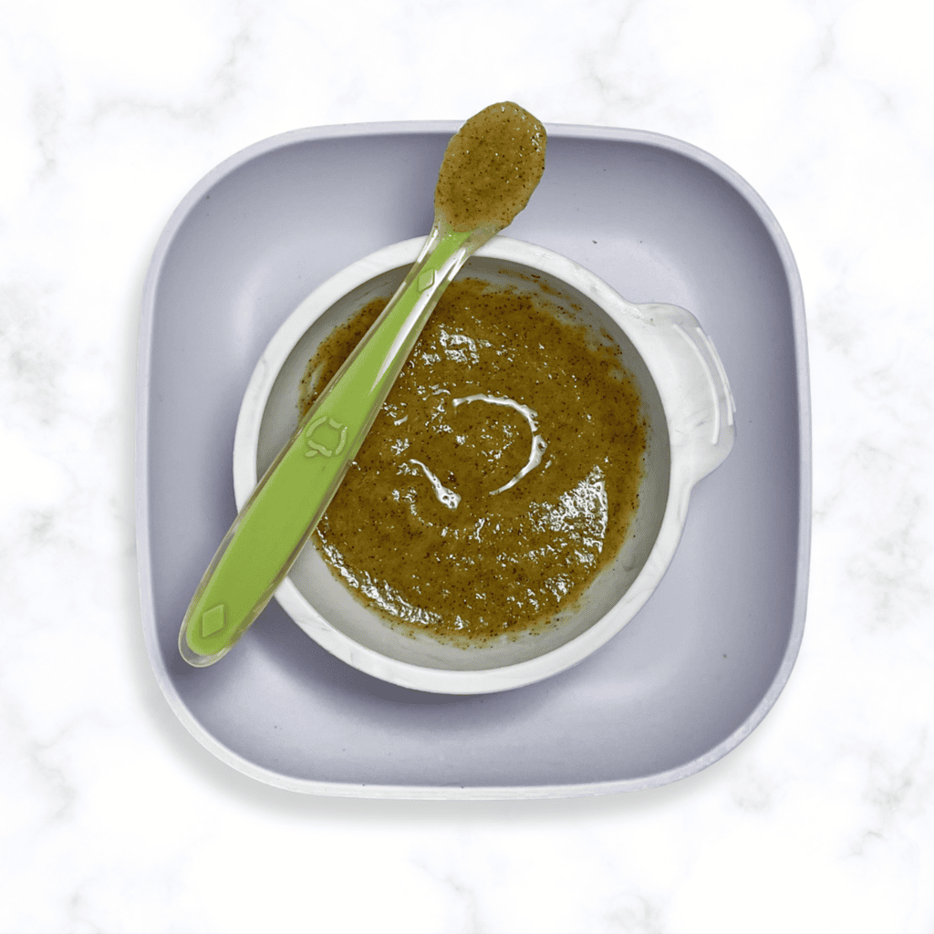 A gray baby bowl with a smooth kiwi puree.