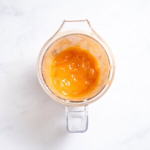 Blender sitting on my kitchen coutner with pureed papaya baby food inside.