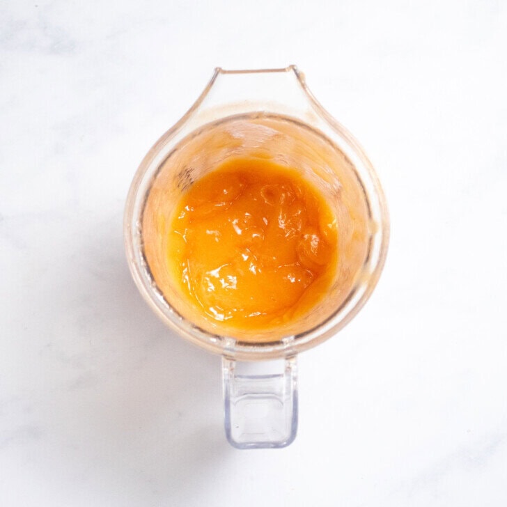 Blender sitting on my kitchen coutner with pureed papaya baby food inside.