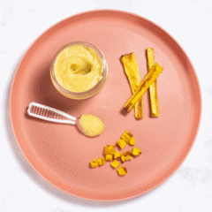 Pink baby plate on a white marble counter with different ways to serve parsnips to your baby - puree, strips for baby-led weaning and chopped for finger foods.
