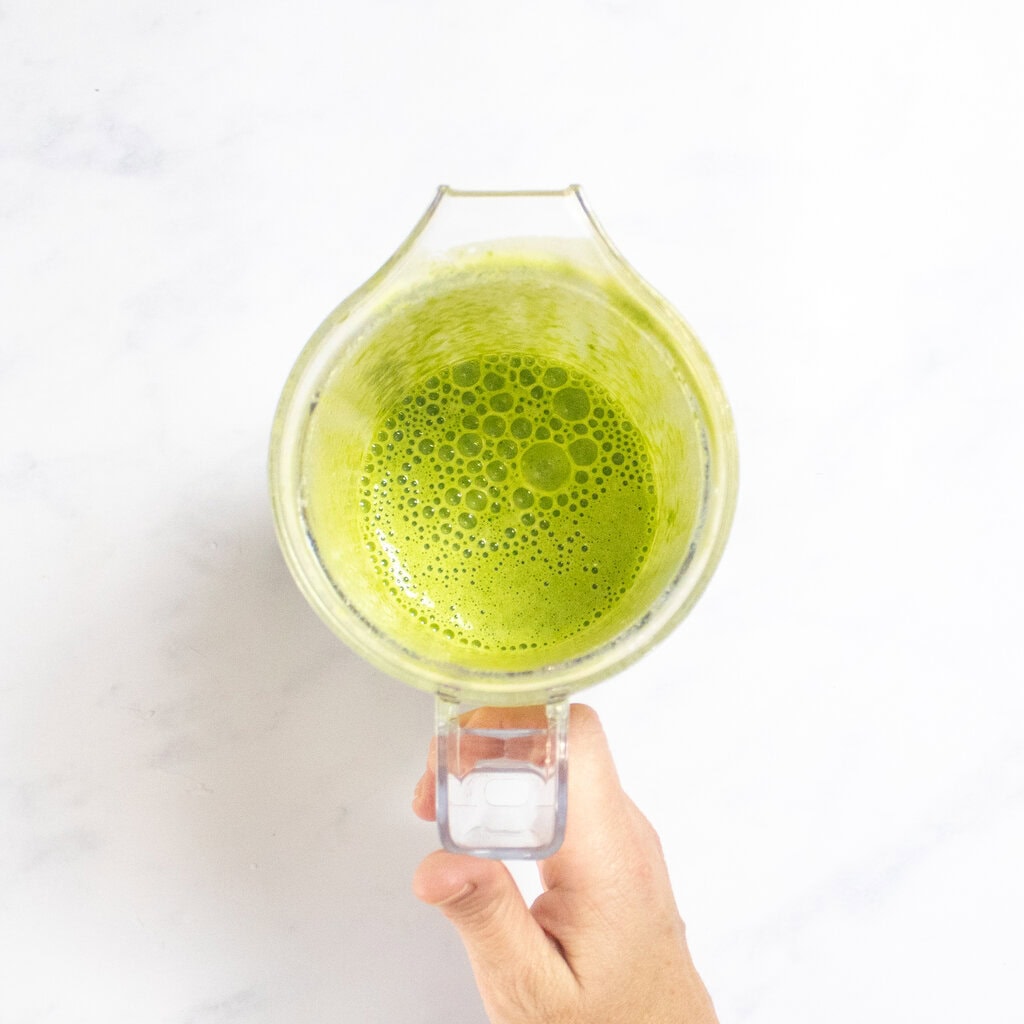 The small blender with the blended spinach and milk.