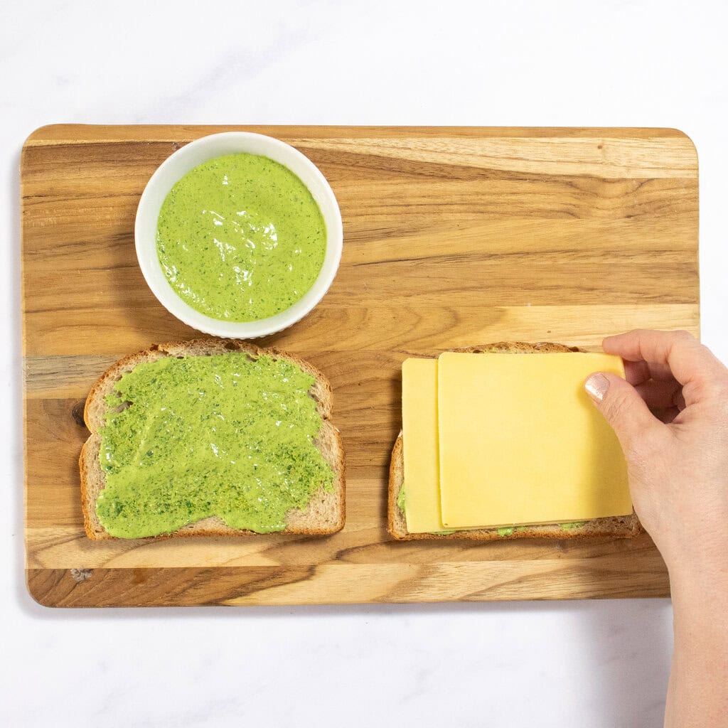 My hands assembling a grilled cheese with the spinach pesto.