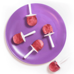 Purple kids plate with raspberry and yogurt popsicles on top. Sitting on a white counter.