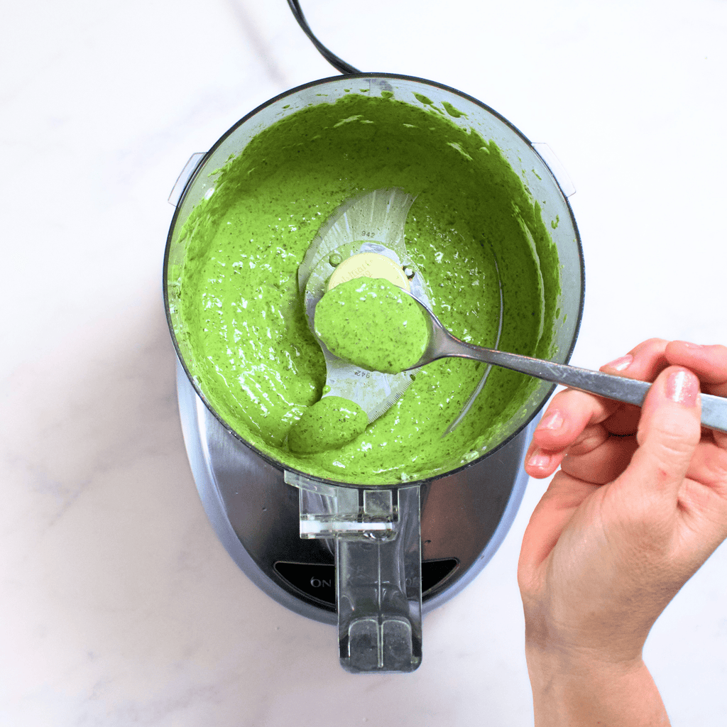 Food processor on my counter with green sauce made with spinach, cream cheese and spices.